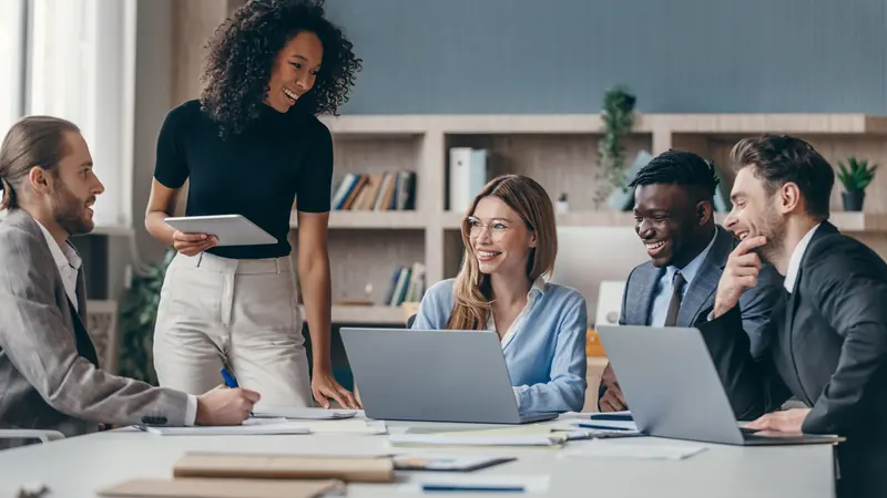 Equipe discutindo a escolha de um sistema em reunião
