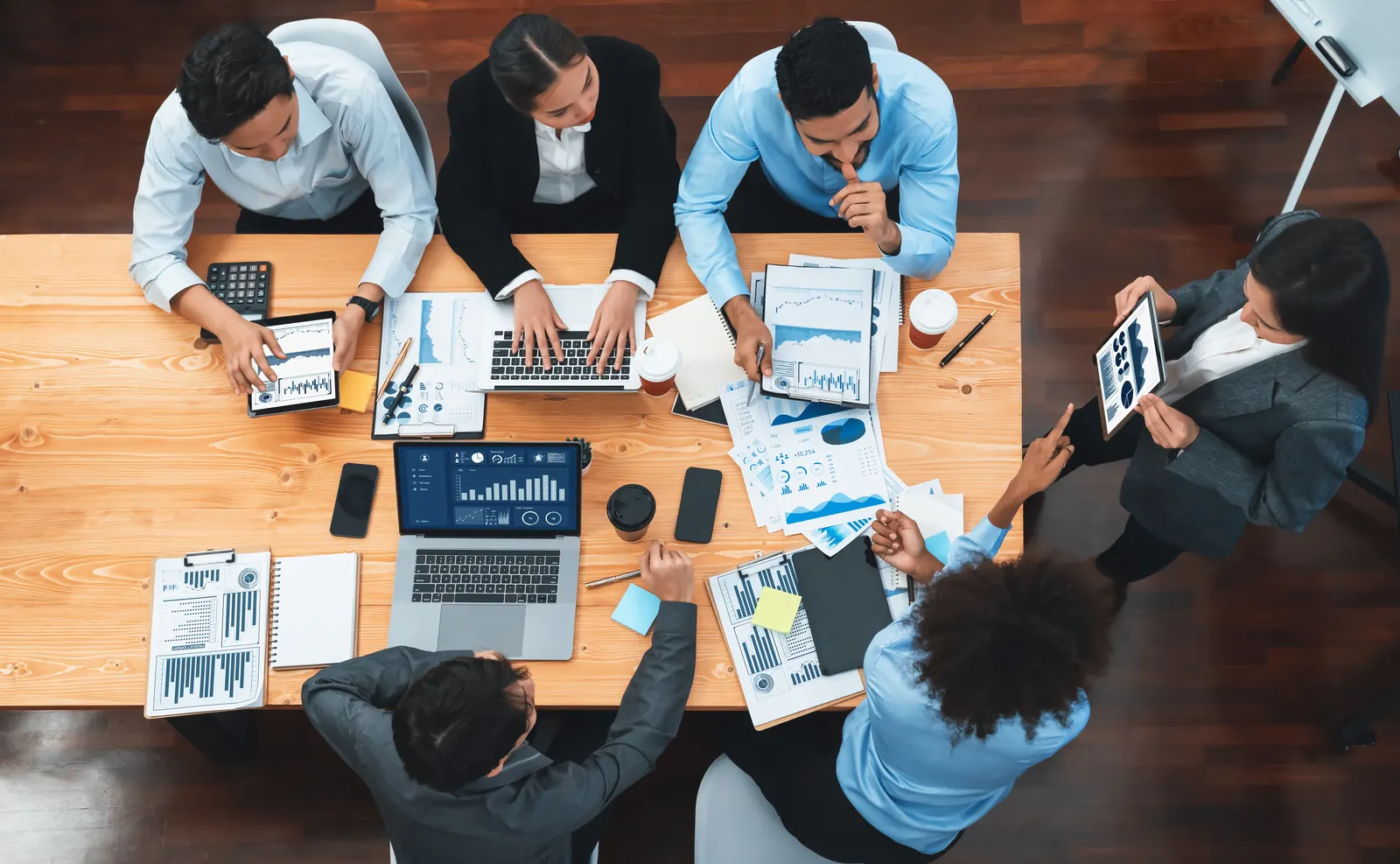 Equipe analisando indicadores e relatórios em uma reunião de projeto
