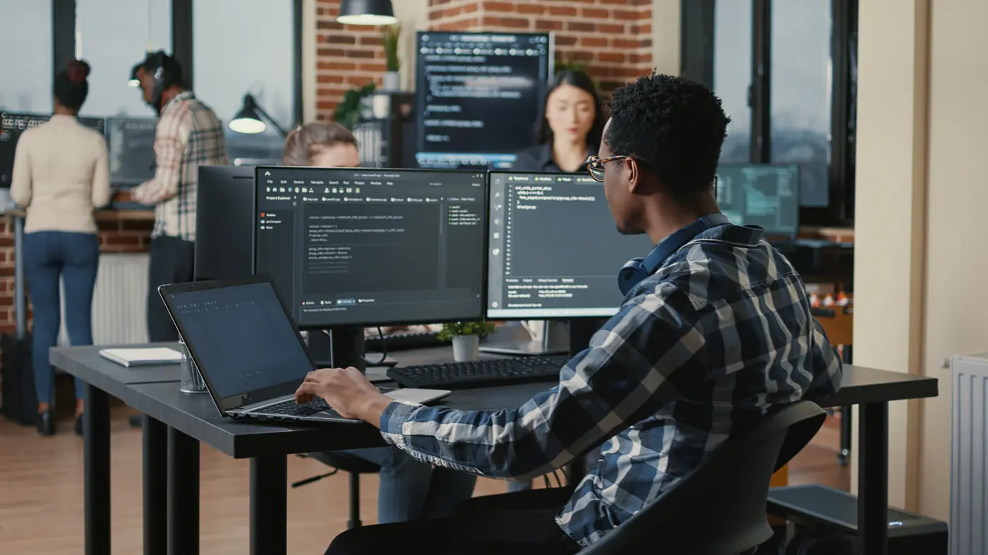 Engenheiro de sistemas trabalhando com vários monitores