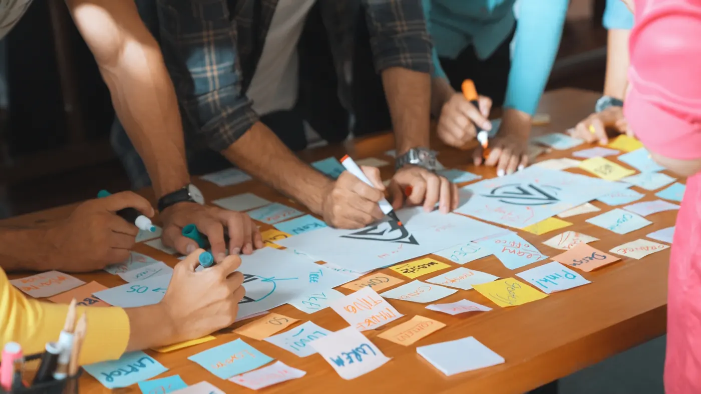 Equipe mapeando processos com notas adesivas sobre a mesa